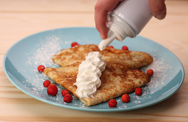 pancakes with wild strawberries  and cream on blue plate stock photo