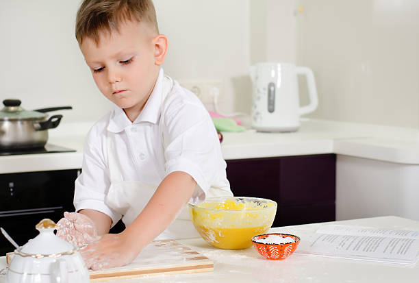 istock Cute little boy learning to bake cakes 481190500
