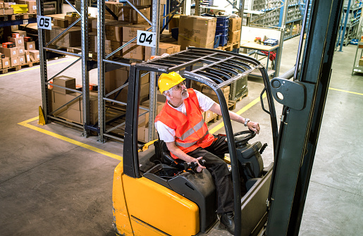 forklift operator at warehouse Loading, lifting cardboard boxes on pallet