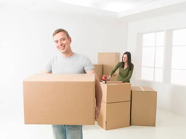 happy young couple packing, preparing to move in new house
