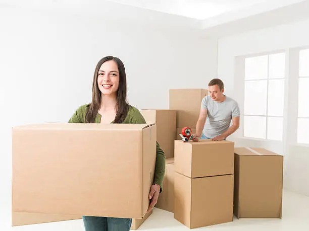 happy young couple packing, preparing to move house