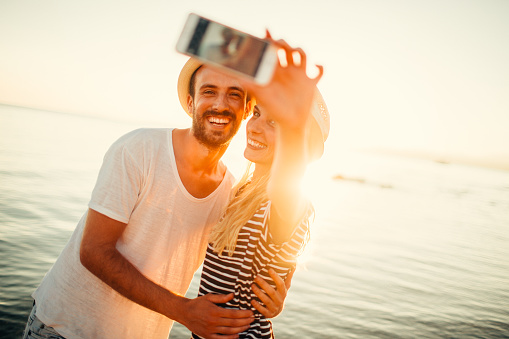 Young smiling couple making a selfie and capturing great moment on their vacation
