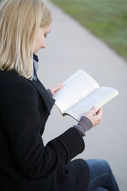 istock Blond Woman Reading Book Outdoors 481203579