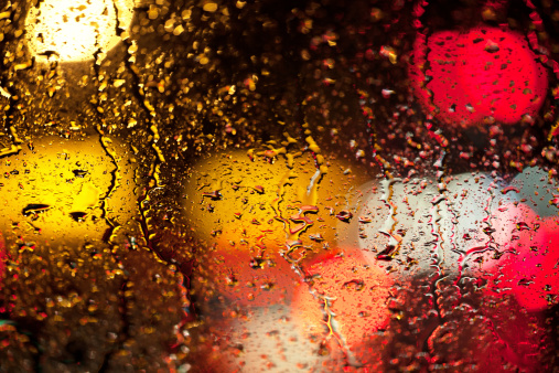 Rain drops on the wind shield of a car.