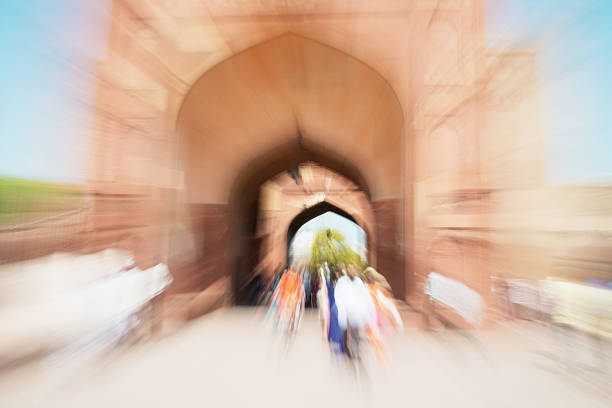 Abstract of large crowd of tourists and visitors walking through the inner gates of  Agra Fort in the City of Agra, India. Zoom-Out Effect to capture the moving crowd motion through the inner archway.