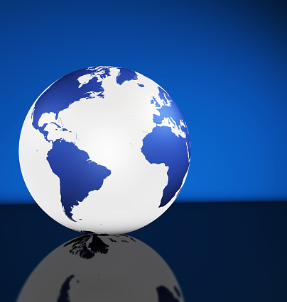 Travel, services and international business management concept with world map on a globe and blue background with copy space.