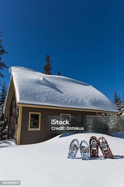 Pairs Of Snowshoes Planted In Snow In Front Of Chalet Stock Photo - Download Image Now