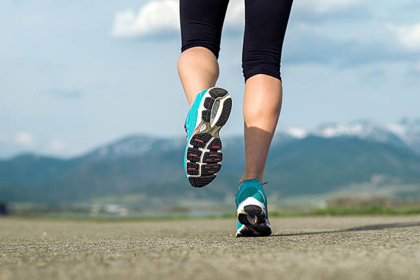 istock Runner athlete feet running on road under sunlight. 481211904
