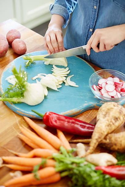 istock Midsection image of woman chopping fennel bulb on rustic board 481216788