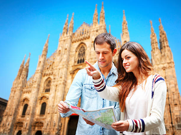 Young couple with map visiting Milan Cathedral Young couple with map visiting Milan Cathedral at Piazza Duomo in Italy amalfi coast map stock pictures, royalty-free photos & images