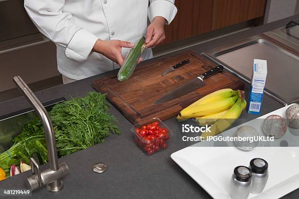 Chef Unwrapping Cucumber At Kitchen Counter Stock Photo - Download Image Now - Adult, Banana, Chef