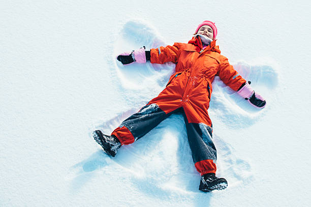 niña hacer un ángel de nieve - bota de la nieve fotografías e imágenes de stock