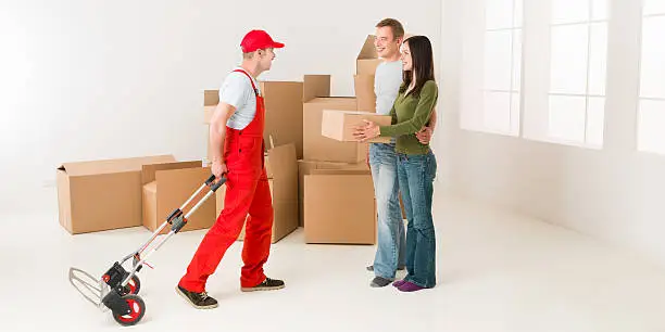 couple moving in new home and receiving package from delivery man