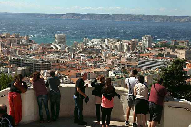 Tourists looking at Marseille from Notre-Dame-de-la-Garde hill, Marseille, France - JULY 01, 2014. Tourists looking at Marseille from Notre-Dame-de-la-Garde hill, France.  Marseille, France  JULY 01, 2014. leisure activity french culture sport high angle view stock pictures, royalty-free photos & images