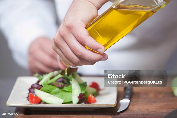 Chef Pouring Olive Oil Over Salad Stock Photo - Download Image Now - Kitchen, Adult, Chef