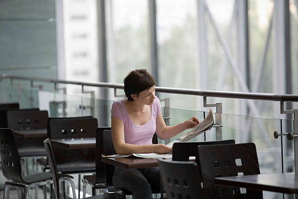 istock Woman Reading Newspaper At Cafe 481252183
