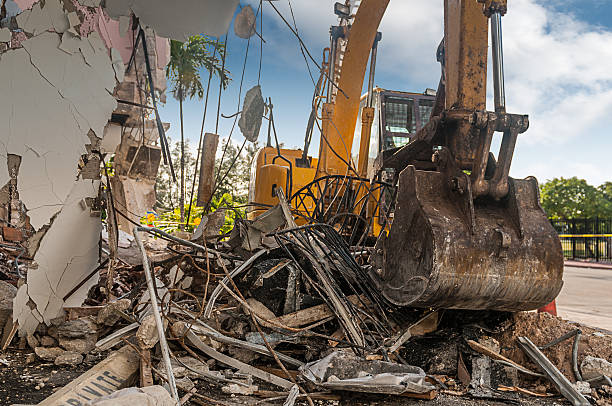 Demolition time A digger makes short work of an old building Earthmoving stock pictures, royalty-free photos & images