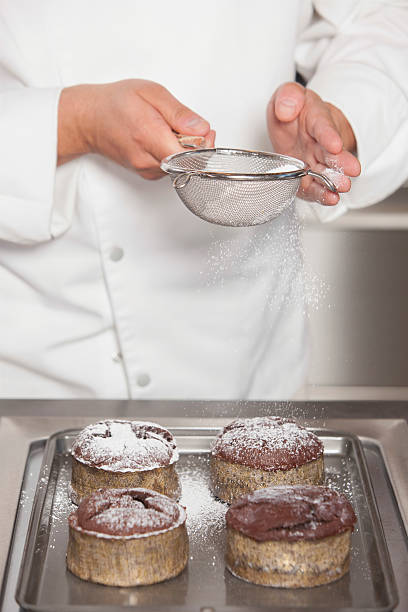 istock Chef Icing Sugar Over Chocolate Cakes At Commercial Kitchen Coun 481253889
