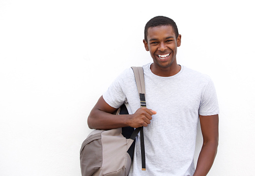 Portrait of a college student smiling with bag on white background