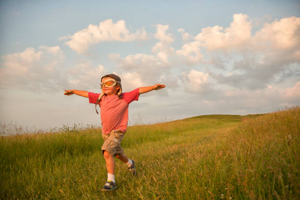 junge englischen jungen präsentiert flying on hill - child discovery outdoors playing stock-fotos und bilder