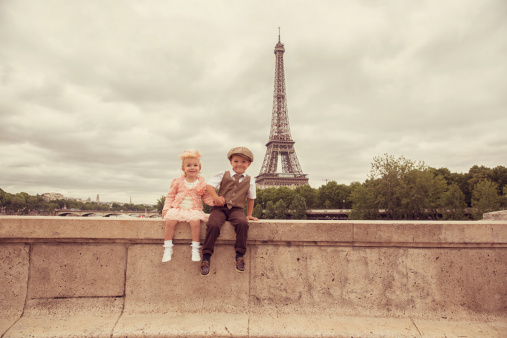 A young boy and girl are spending some quality time in Paris, the city of Love.