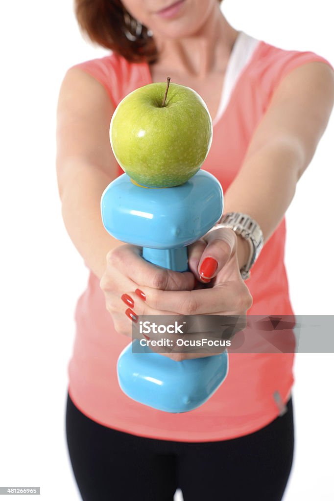 Mujer agarrando gimnasio peso y manzana en saludable concepto de nutrición - Foto de stock de Adulto libre de derechos