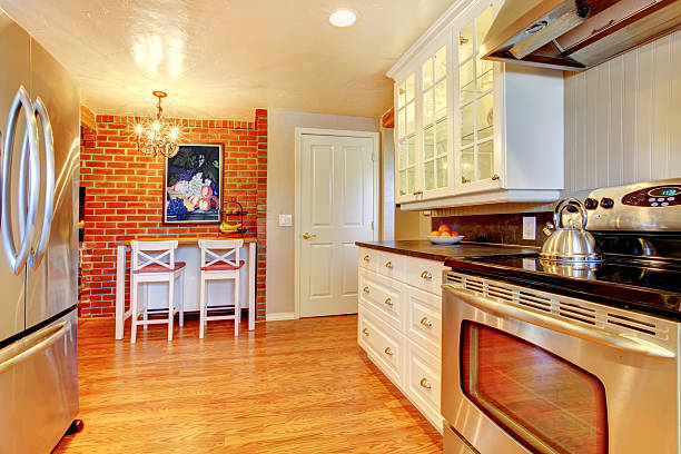 istock White kitchen with brick wall, hardwood and stainless steal stove. 481268509