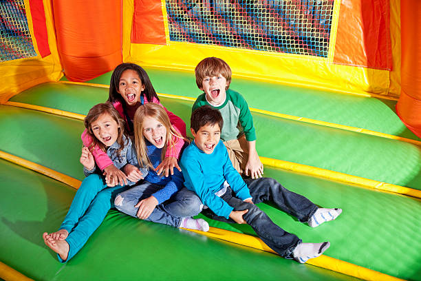 kinder in bounce house - house bouncing multi colored outdoors stock-fotos und bilder