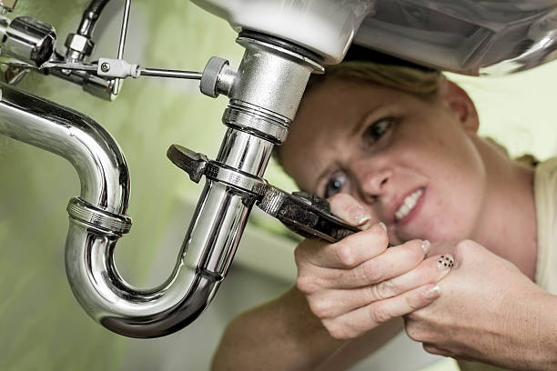 istock Housewife tightening a siphon under the sink 481284451