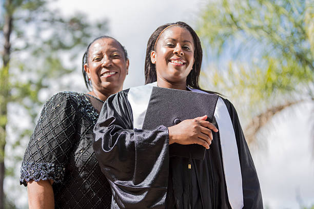 Proud mother poses with her daughter at graduation stock photo