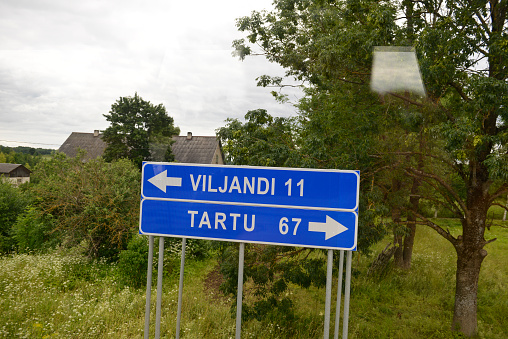 Highway sign directing traffic to Viljandi and Tartu, Estonia. Photo taken from a bus window.