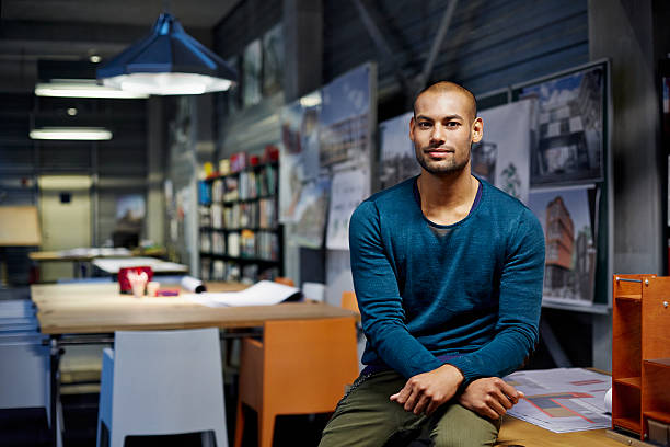 Portrait of architect Portrait of male architect at workstation in modern studio three quarter length stock pictures, royalty-free photos & images