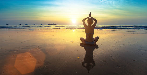 istock Woman doing meditation near the ocean beach. 481294272