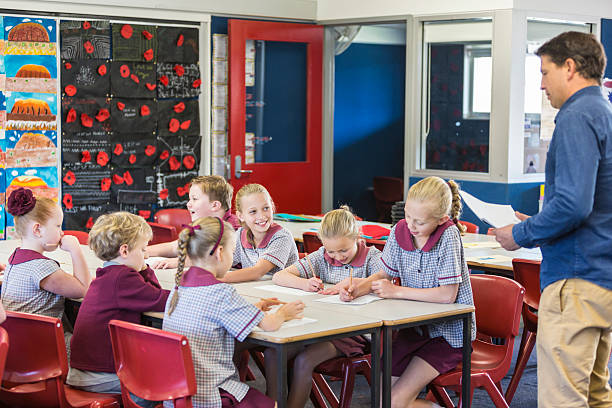 School children working with their teacher in the class room