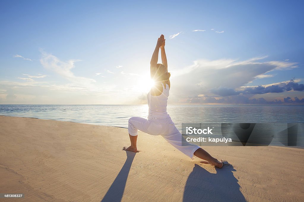 Caucasian woman practicing yoga at seashore Adult Stock Photo