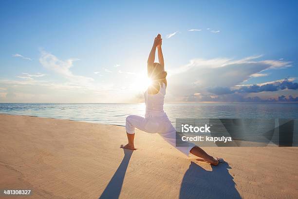 Caucasian Woman Practicing Yoga At Seashore Stock Photo - Download Image Now - Adult, Adults Only, Beach