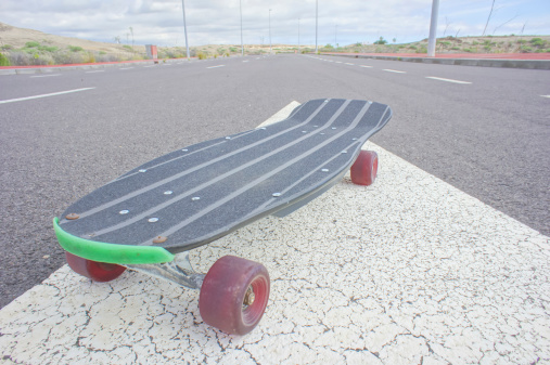 Vintage Style Longboard Black Skateboard on an Empty Asphalt Desert Road