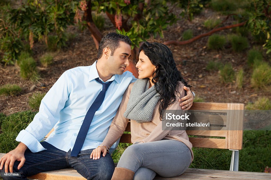 Couple sitting on a bench Romantic loving couple sitting on a bench 2015 Stock Photo