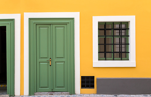 Details of a yellow house with green door and window