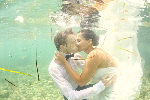 istock Bride and groom kissing under water 481315498