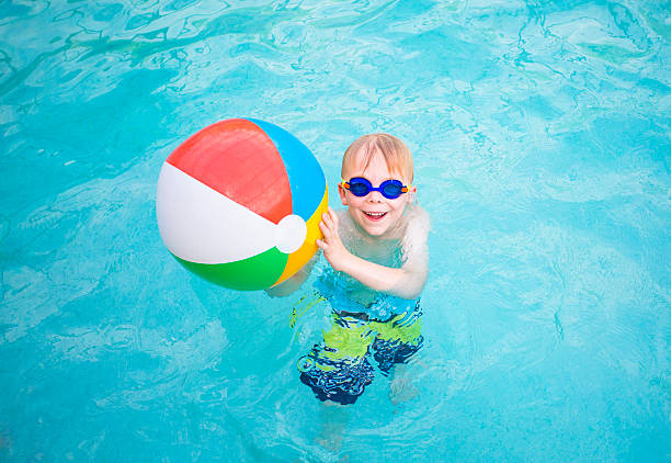 istock Cute little boy playing with Beach ball in swimming pool 481319316