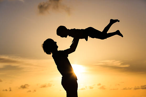 istock father and little son silhouettes play at sunset 481319976