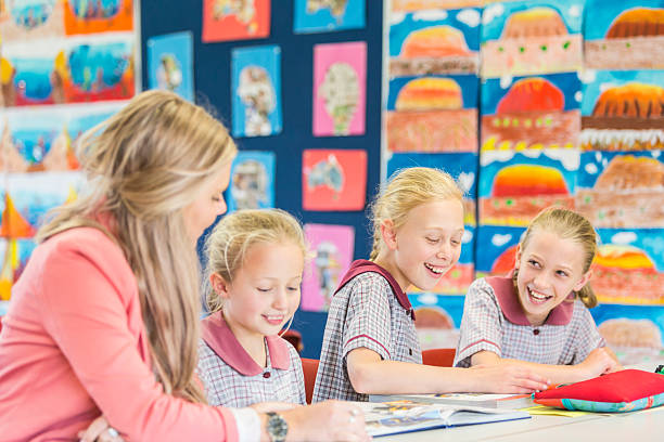 istock Smiling School Girls Laughing and Learning in the Classroom 481321394