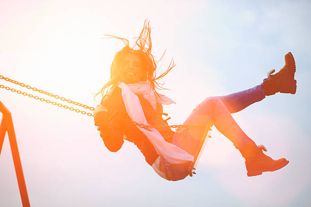 istock Young woman having fun swinging in sunlight 481323345