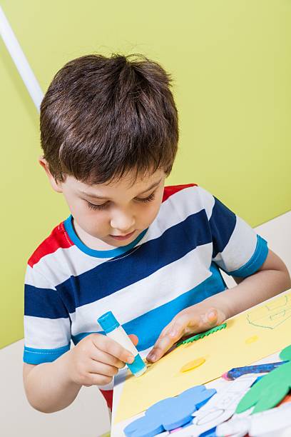 istock Preschool boy use glue for homework 481325244