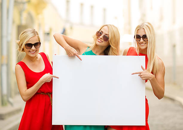 three happy blonde women with blank white board