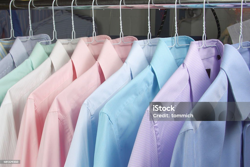 shirt on hang of newly ironed shirts in dry cleaners placed on a coat rack. Dry Cleaner Stock Photo