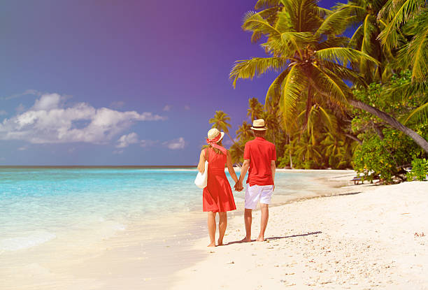 istock happy loving couple walking on tropical beach 481330004
