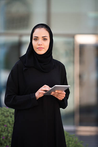 istock Traditionally Dressed Middle Eastern Woman with Tablet Outside Office Entrance 481332804