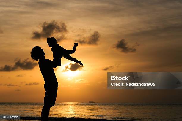 Father And Little Daughter Silhouettes At Sunset Stock Photo - Download Image Now - 2015, Adult, Baby - Human Age